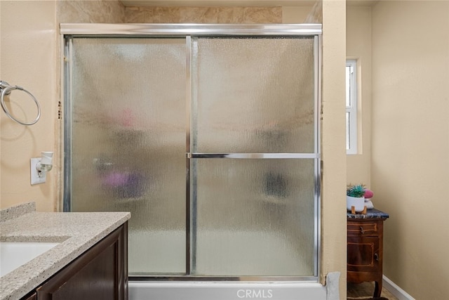 bathroom featuring vanity and bath / shower combo with glass door