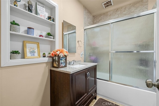 bathroom featuring vanity and bath / shower combo with glass door