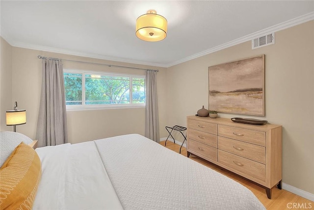 bedroom with crown molding and light wood-type flooring