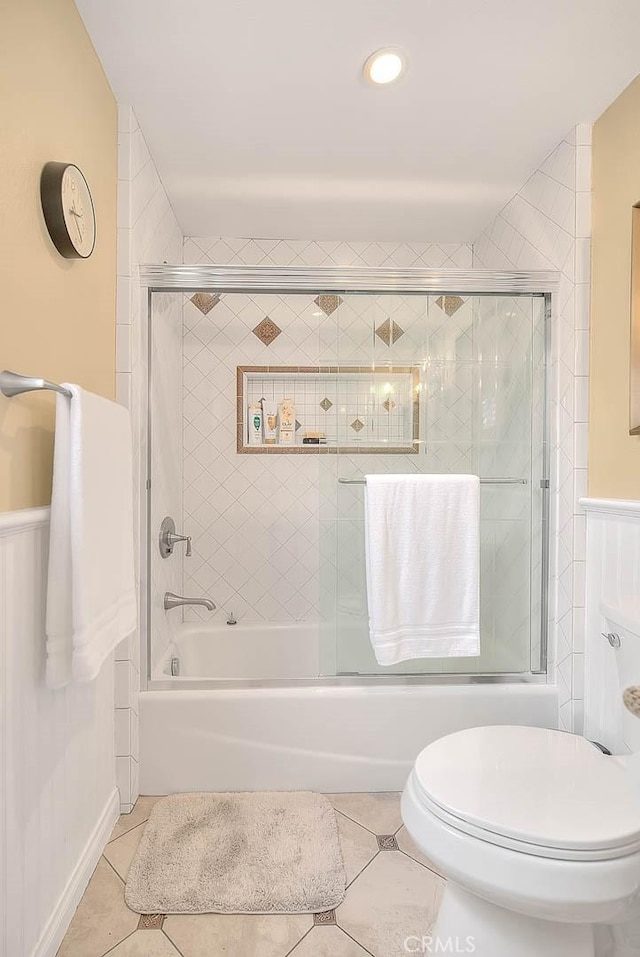 bathroom featuring enclosed tub / shower combo, tile patterned floors, and toilet