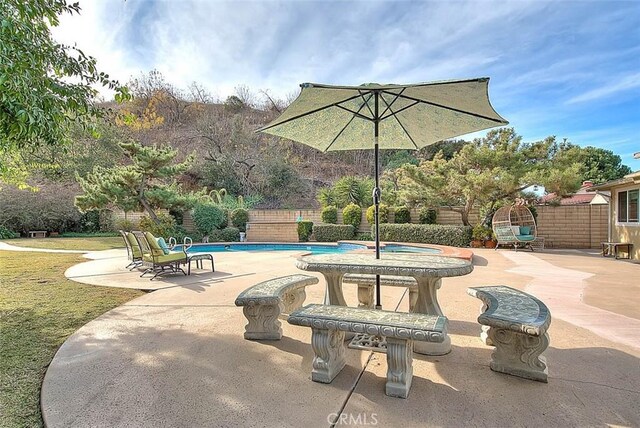 view of patio featuring a swimming pool with hot tub