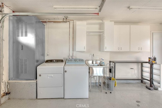 laundry room with cabinets, sink, and washer and clothes dryer