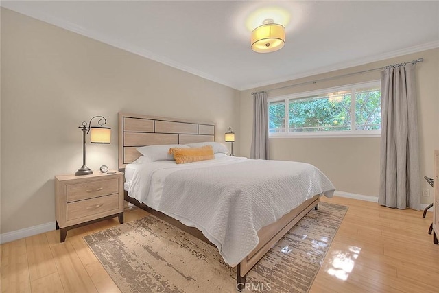 bedroom with crown molding and light wood-type flooring