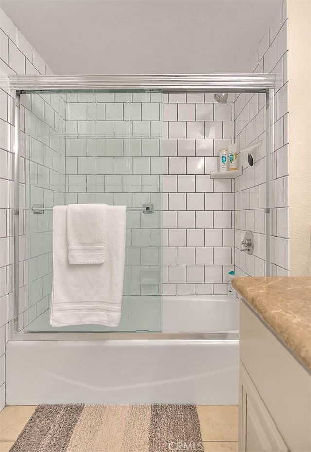 bathroom featuring enclosed tub / shower combo, vanity, and tile patterned flooring