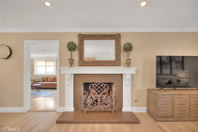 living room featuring hardwood / wood-style floors, a fireplace, and ornamental molding