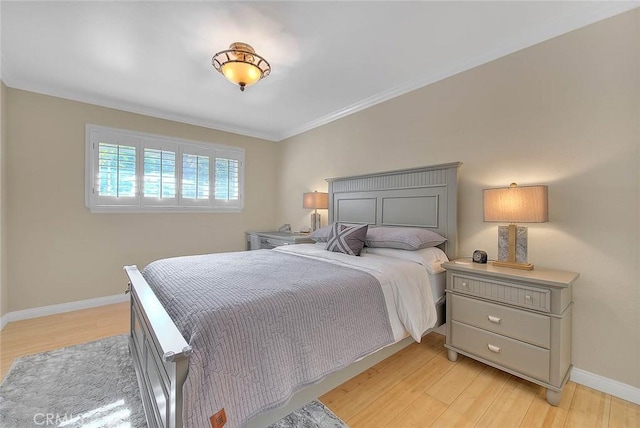 bedroom with crown molding and light wood-type flooring