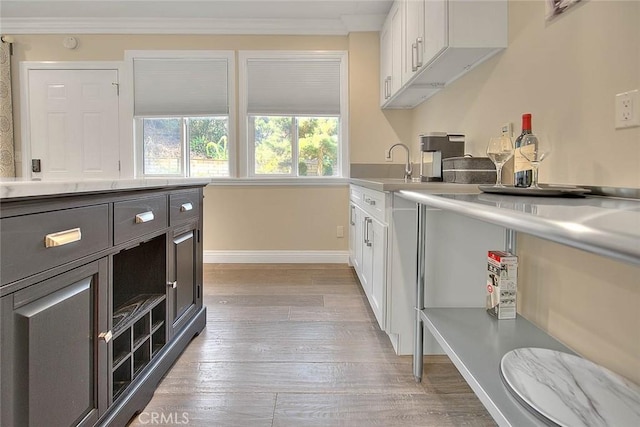 kitchen featuring sink, light hardwood / wood-style floors, and white cabinets