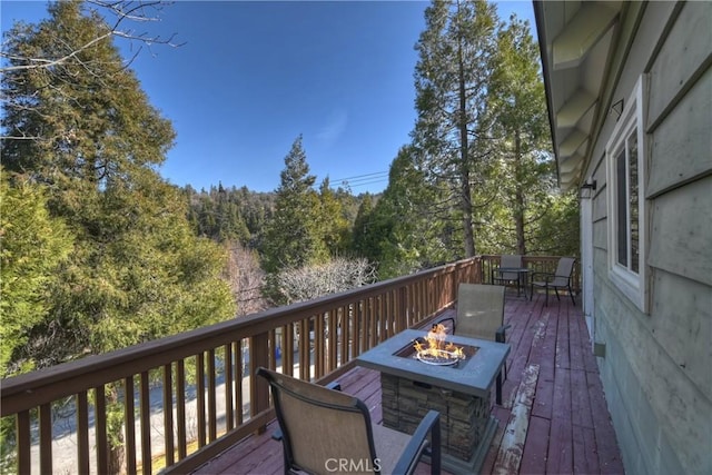 wooden terrace featuring an outdoor fire pit and outdoor dining area