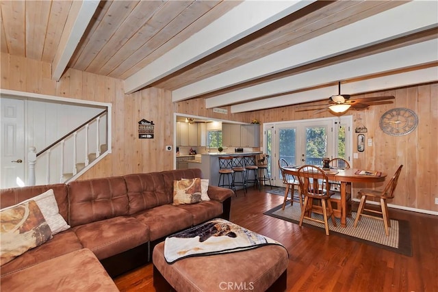 living room with ceiling fan, dark hardwood / wood-style floors, beam ceiling, and french doors