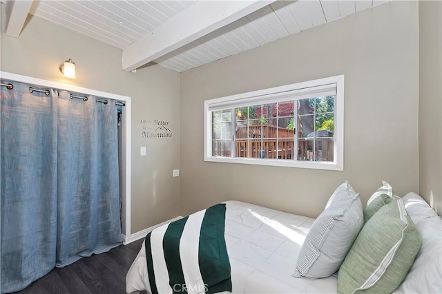 bedroom featuring dark hardwood / wood-style flooring and beam ceiling