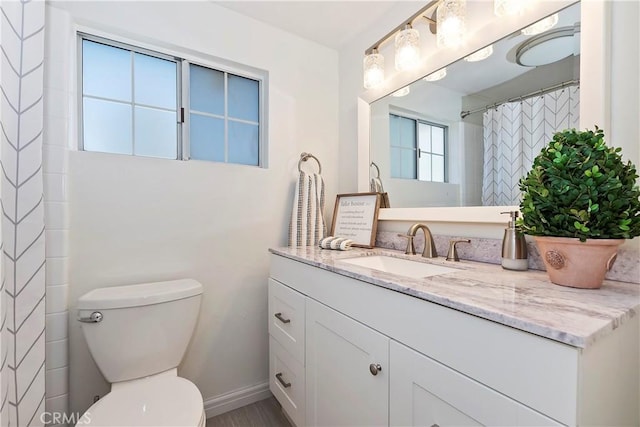 bathroom with vanity, a shower with shower curtain, and toilet