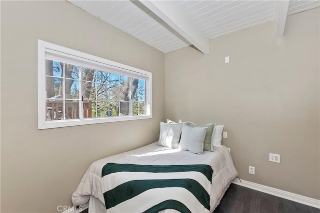 bedroom with beamed ceiling, wood finished floors, and baseboards