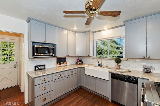 kitchen featuring dark hardwood / wood-style flooring, sink, backsplash, and appliances with stainless steel finishes