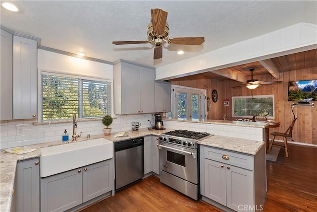 28621 Shenandoah Dr, Lake Arrowhead, CA 92352 - kitchen featuring stainless steel appliances, gray cabinetry, a ceiling fan, a peninsula, and wood walls