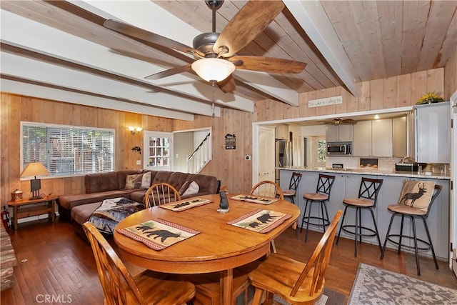 28621 Shenandoah Dr, Lake Arrowhead, CA 92352 - dining area with a ceiling fan, wood walls, dark wood-type flooring, and a wooden ceiling with exposed beams