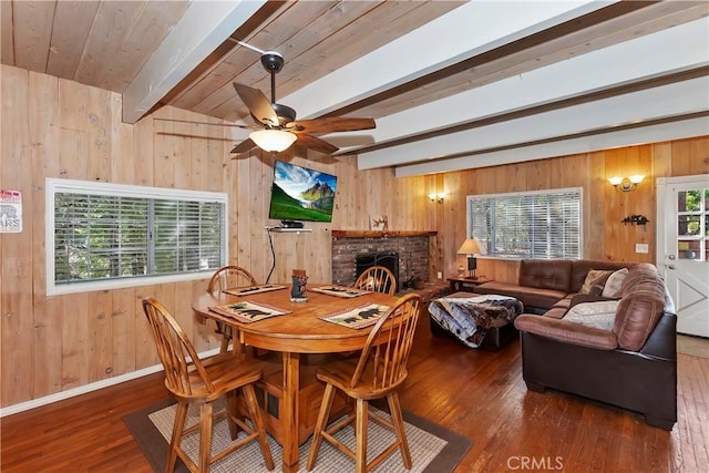 28621 Shenandoah Dr, Lake Arrowhead, CA 92352 - dining space featuring wooden walls, wood-type flooring, a ceiling fan, a fireplace, and a wood ceiling with exposed beams