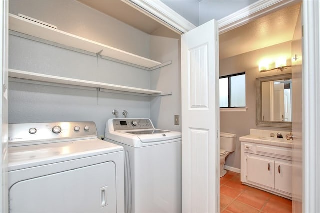 clothes washing area with light tile patterned floors, sink, and washer and dryer