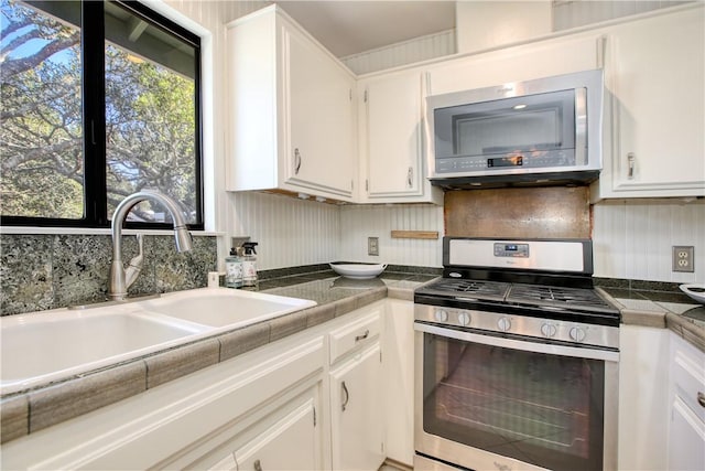 kitchen featuring white cabinetry, sink, decorative backsplash, and appliances with stainless steel finishes