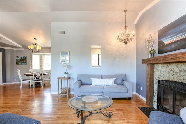 living room featuring hardwood / wood-style floors, a fireplace, and a chandelier