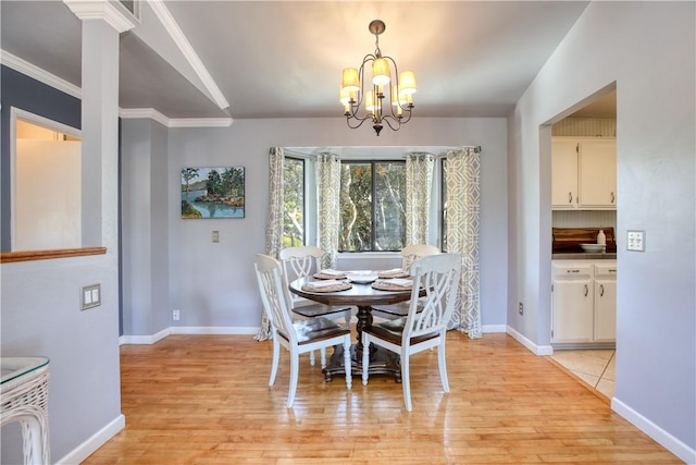 dining area featuring crown molding, a chandelier, and light hardwood / wood-style floors