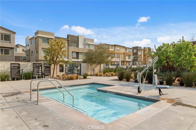 view of swimming pool with a patio and fence