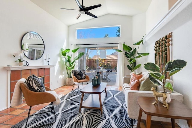 sitting room featuring ceiling fan, tile patterned floors, a fireplace, and lofted ceiling