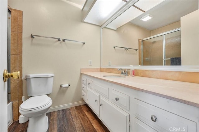 full bathroom with shower / bath combination with glass door, vanity, toilet, and hardwood / wood-style floors