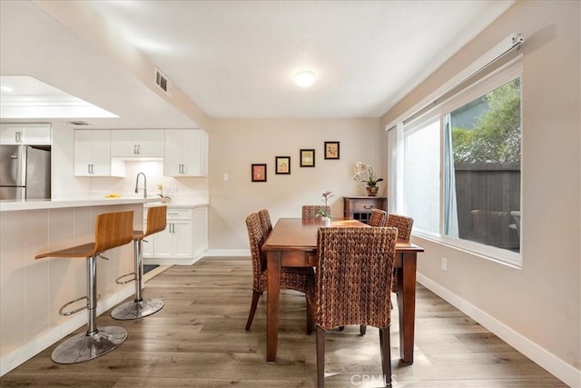 dining space featuring wood-type flooring and sink