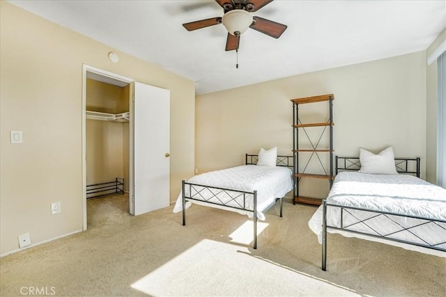 bedroom featuring a walk in closet, baseboard heating, ceiling fan, a closet, and light colored carpet