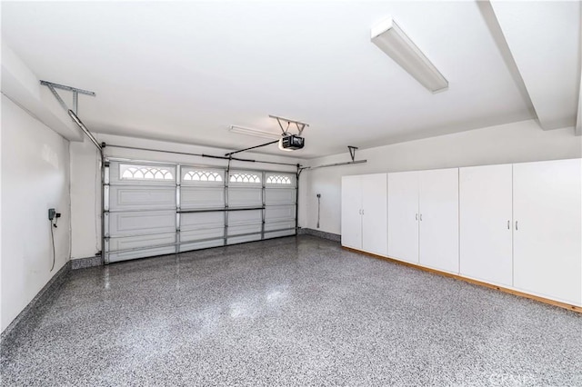 garage with a garage door opener and baseboards