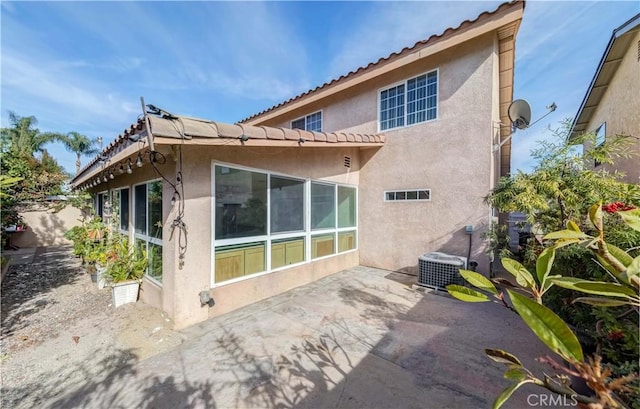 back of property with cooling unit, a patio, and stucco siding