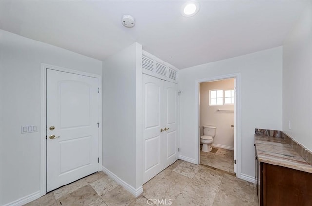 bathroom with toilet and baseboards