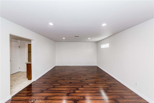 unfurnished room with baseboards, visible vents, wood finished floors, and recessed lighting