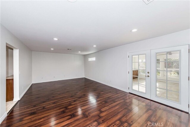 empty room featuring dark hardwood / wood-style floors and french doors