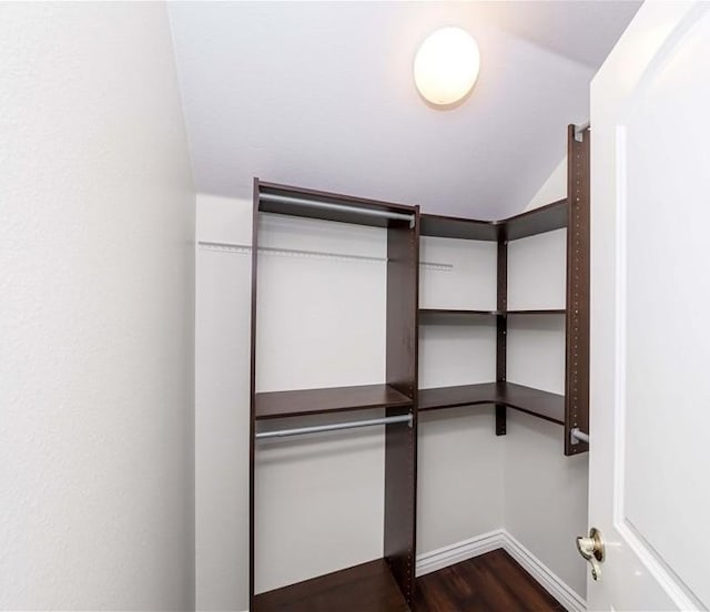 walk in closet featuring dark wood-type flooring and lofted ceiling