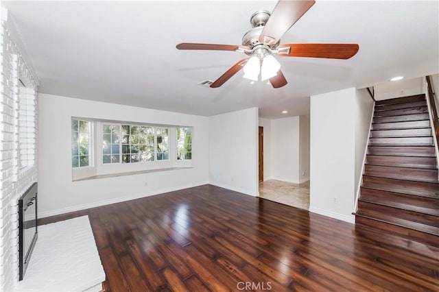 unfurnished living room with ceiling fan, dark hardwood / wood-style floors, and a fireplace