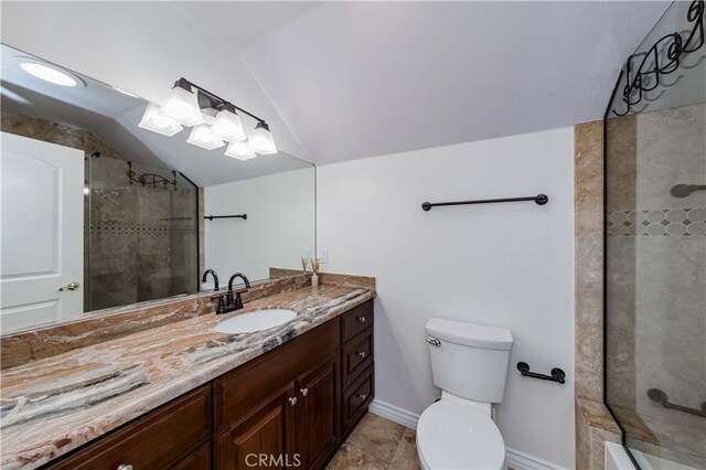 bathroom with lofted ceiling, toilet, vanity, and a tile shower