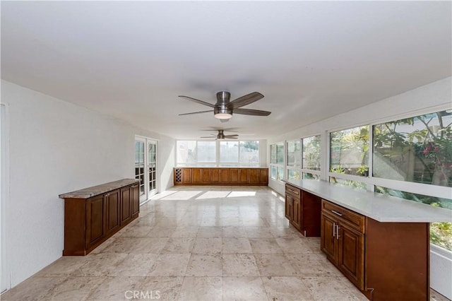 unfurnished sunroom with ceiling fan