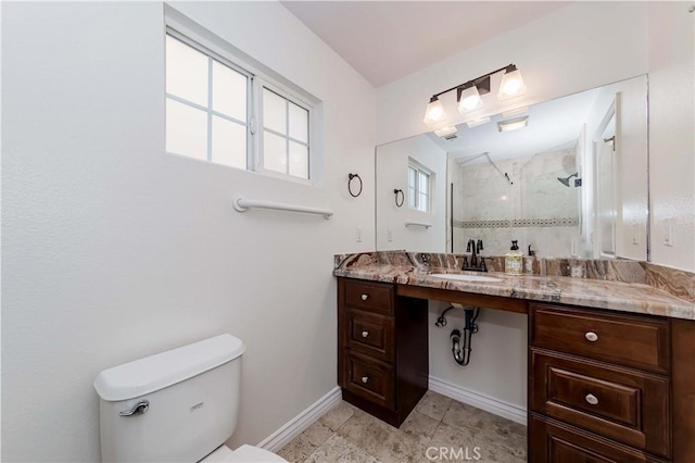 full bathroom with a stall shower, baseboards, vanity, and toilet