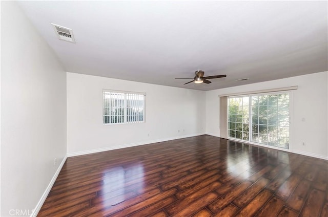 spare room with visible vents, ceiling fan, baseboards, and wood finished floors