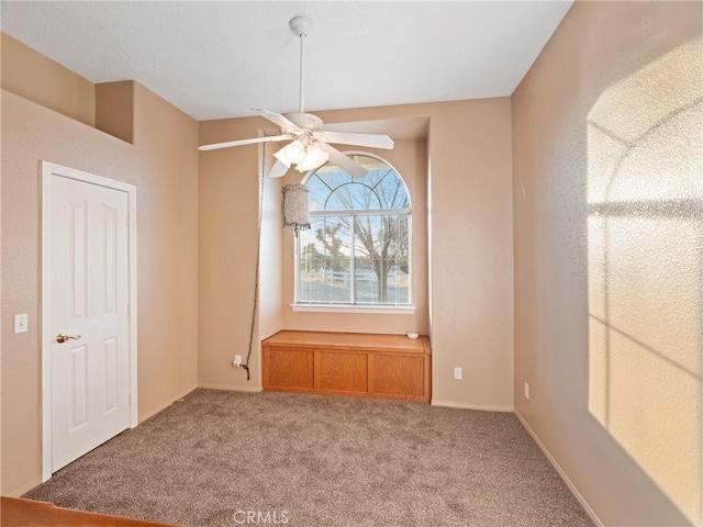 carpeted spare room with ceiling fan