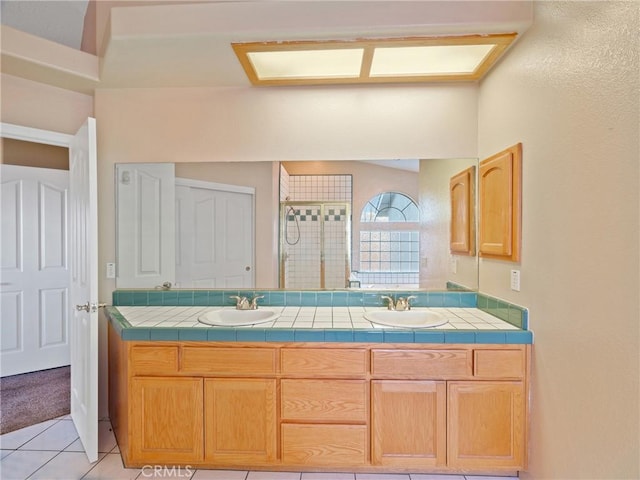 bathroom with vanity, a shower with shower door, and tile patterned floors