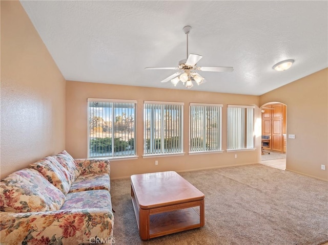 carpeted living room with ceiling fan