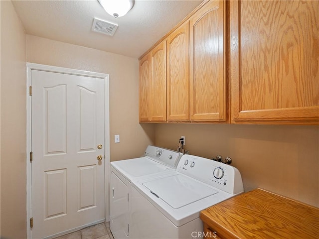 laundry room featuring cabinets, light tile patterned flooring, and independent washer and dryer