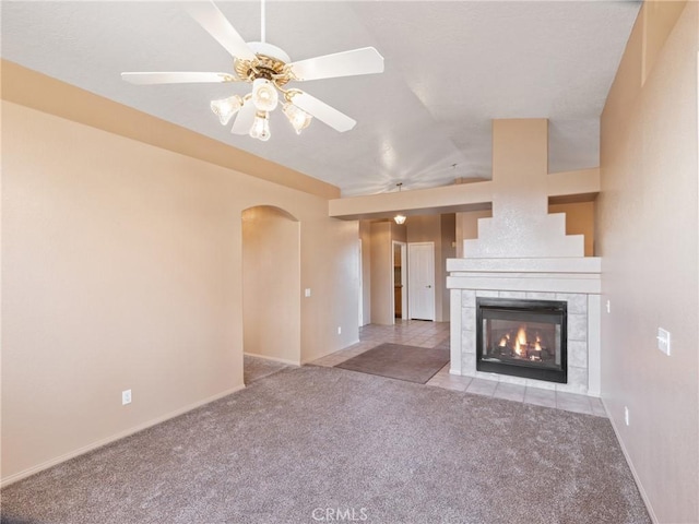 unfurnished living room featuring ceiling fan, light colored carpet, and a fireplace