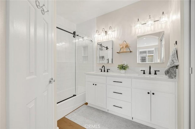 bathroom with vanity, hardwood / wood-style floors, and bath / shower combo with glass door