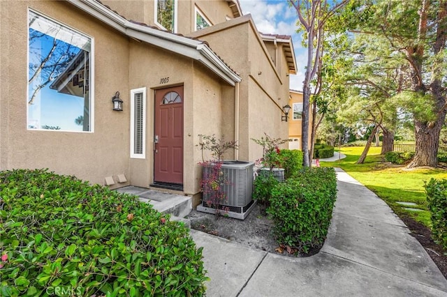 entrance to property with central AC and a yard