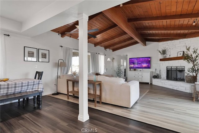 living room with vaulted ceiling with beams, wood-type flooring, wooden ceiling, ceiling fan, and a fireplace