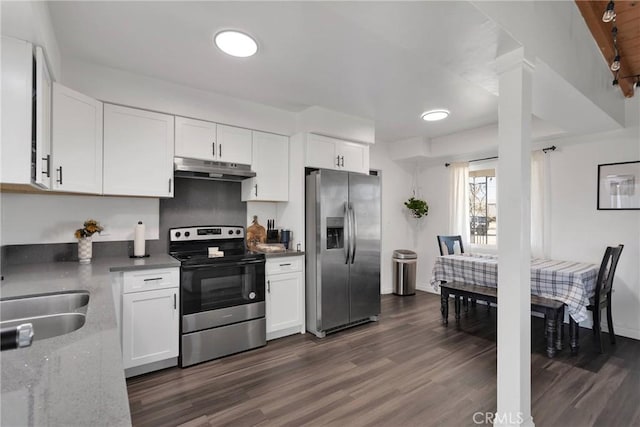 kitchen with appliances with stainless steel finishes, dark hardwood / wood-style flooring, and white cabinets