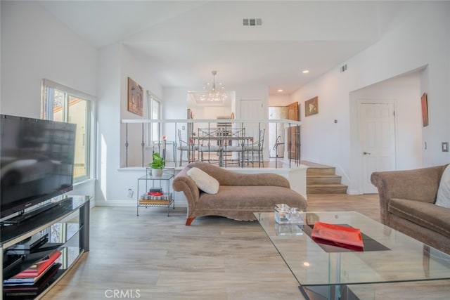 living room with a notable chandelier and light hardwood / wood-style floors